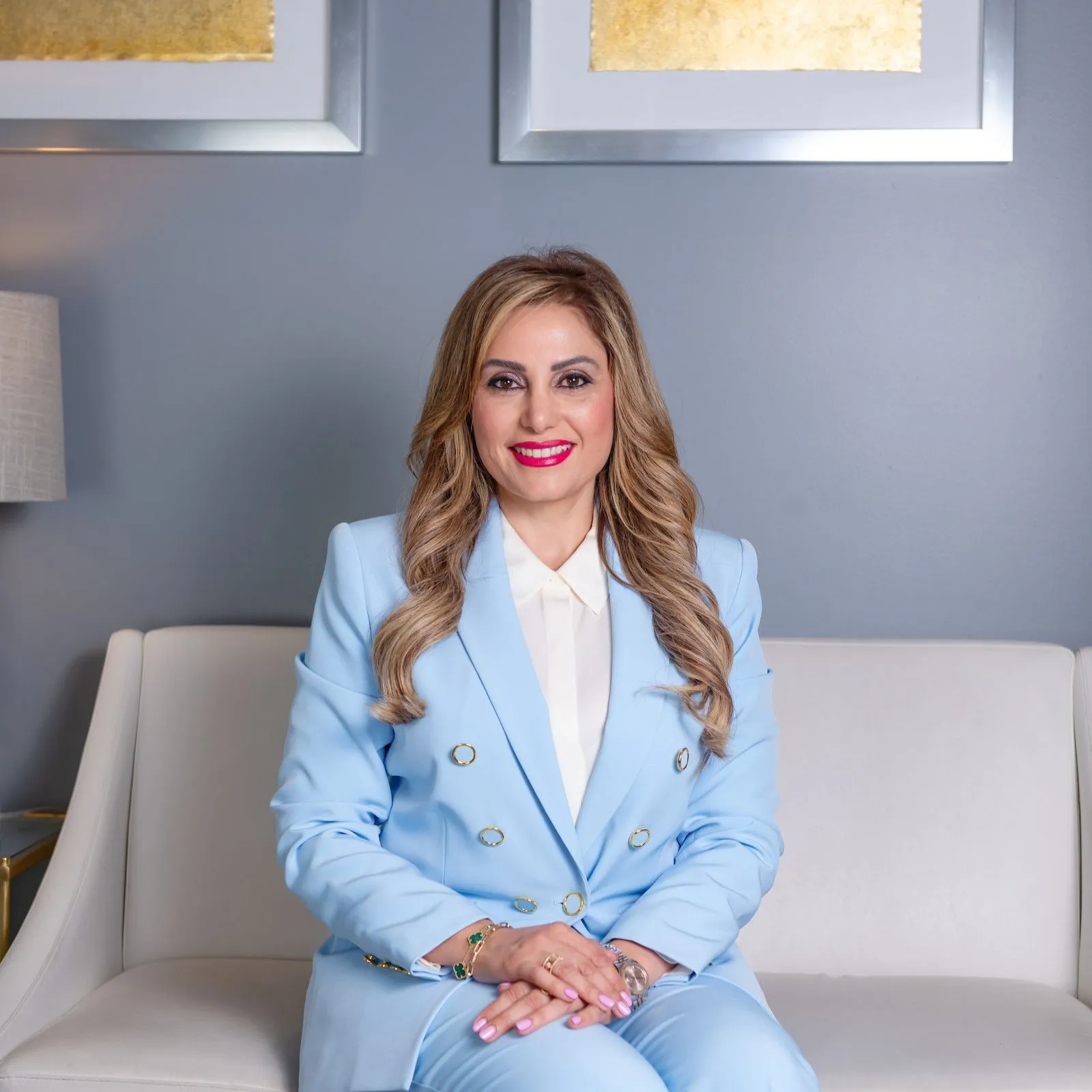 Fertility expert Susan Nasab MD sitting on a white sofa